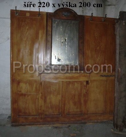 Wooden wall with hangers and mirror